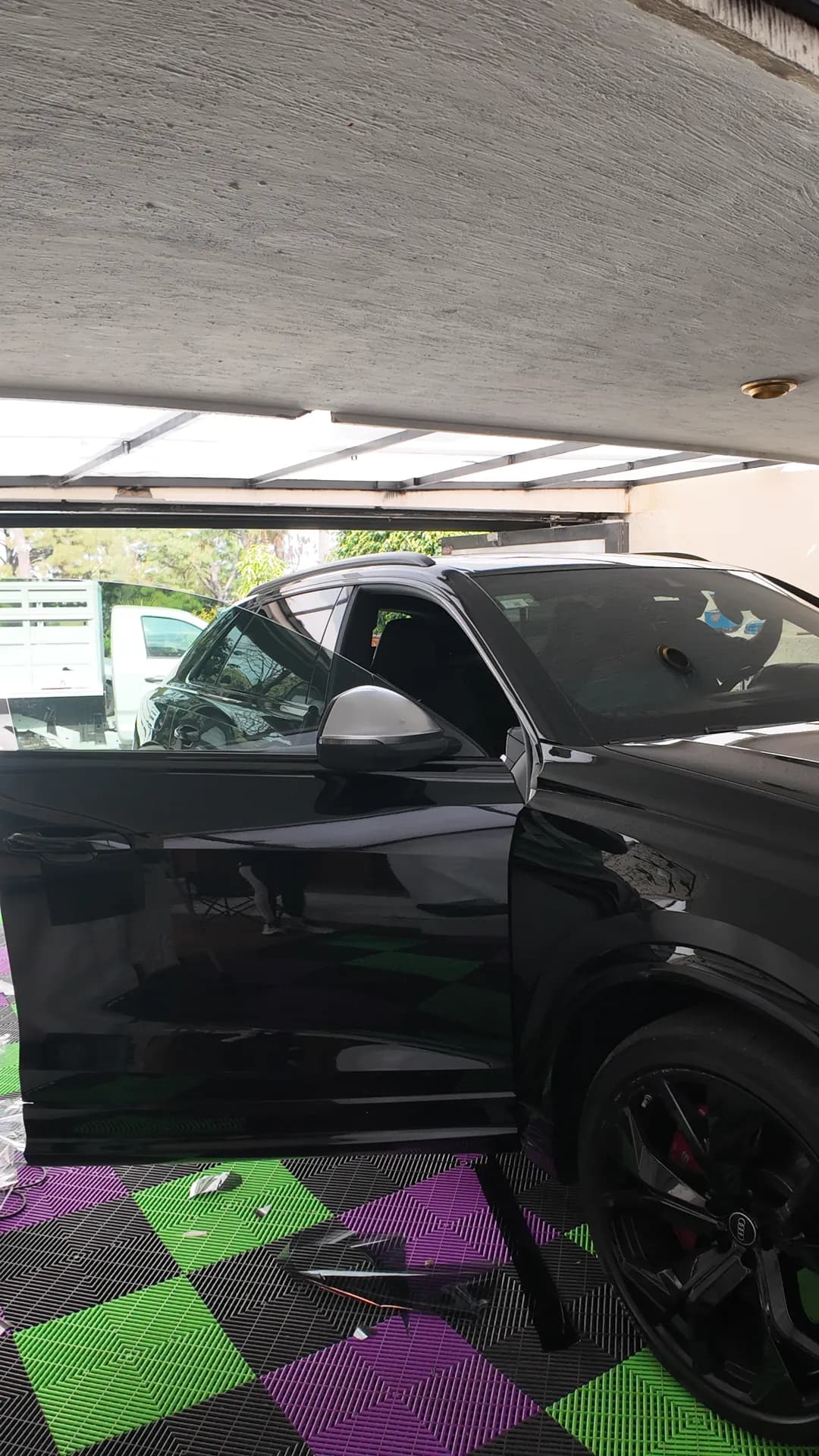 SUV negra con la puerta abierta durante la instalación de polarizado en el taller de HIGHTECH.