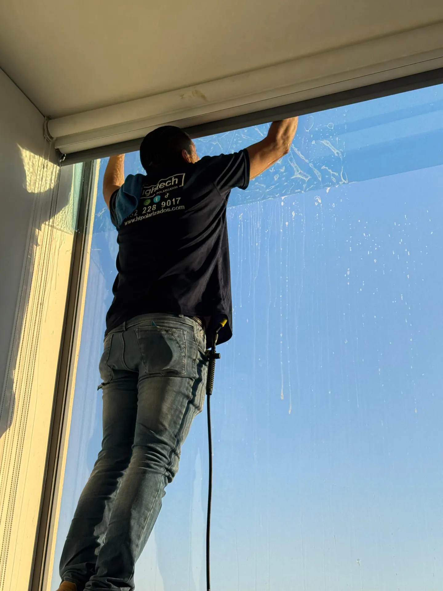 Aplicación de película sobre un cristal residencial, trabajo documentado por HIGHTECH.