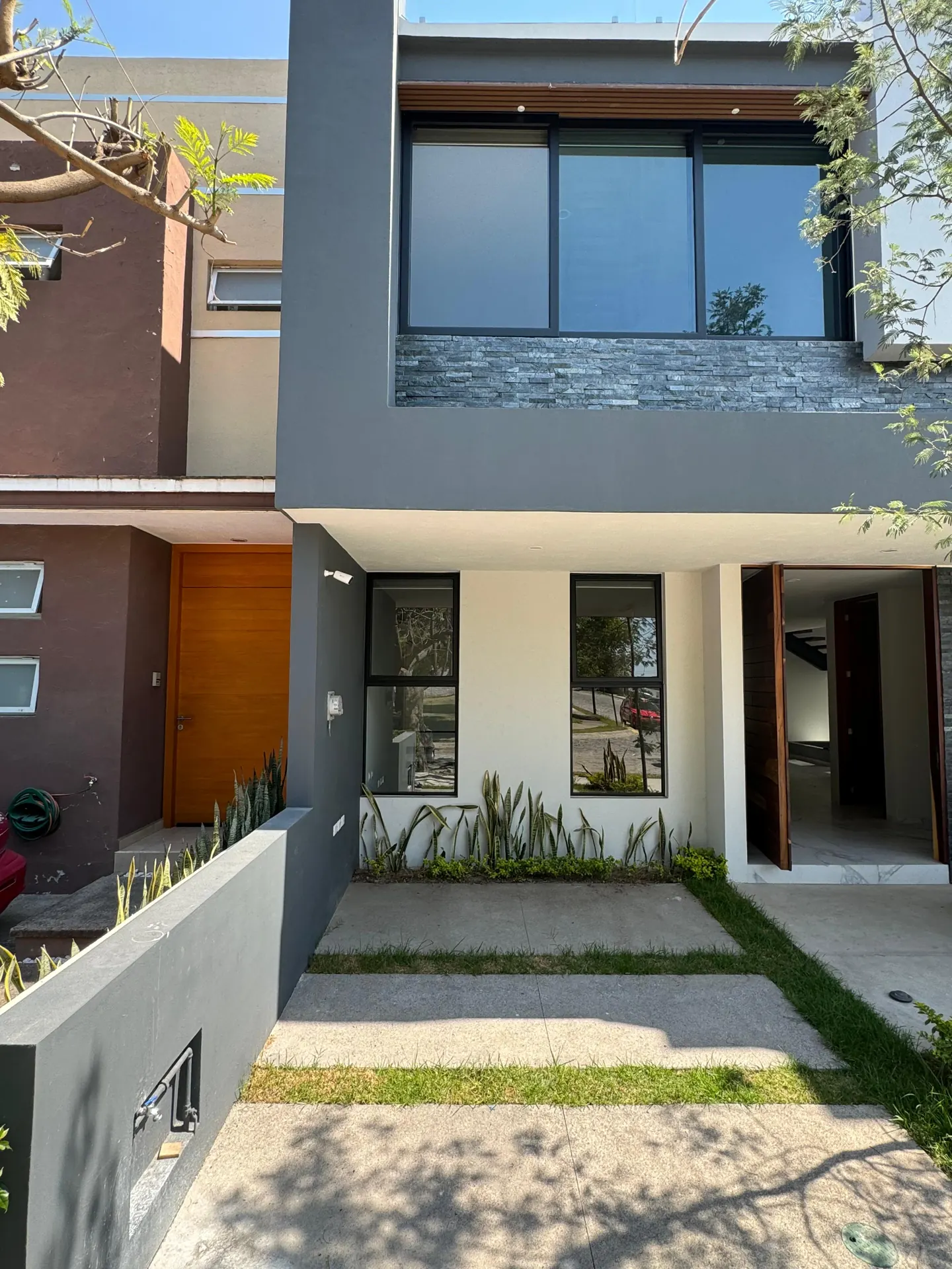 Fachada de una casa con ventanales, trabajo documentado por HIGHTECH.