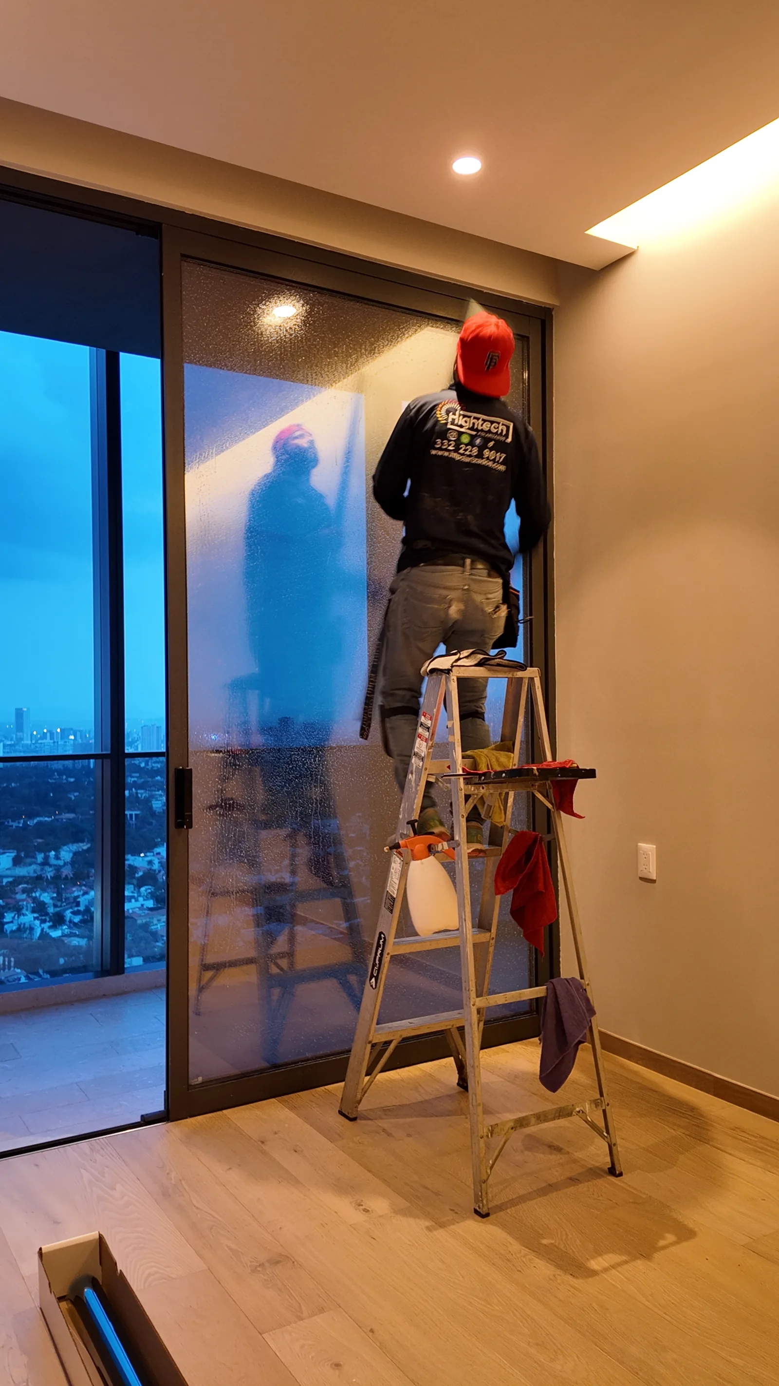 Instalación de película sobre un cristal en vertical, trabajo documentado por HIGHTECH.