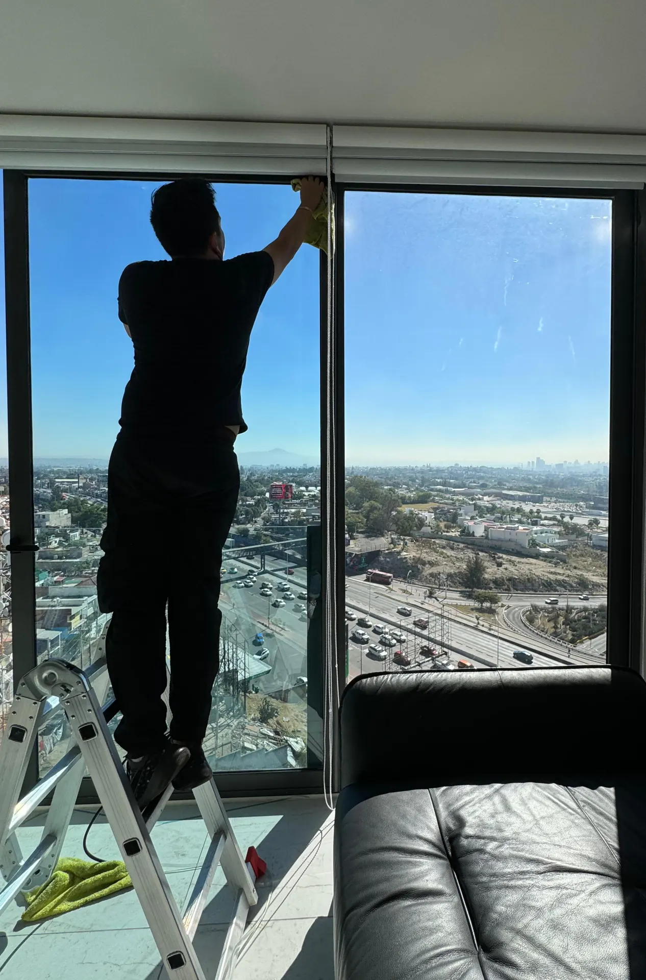 Instalador aplicando película en una torre residencial, trabajo documentado por HIGHTECH.